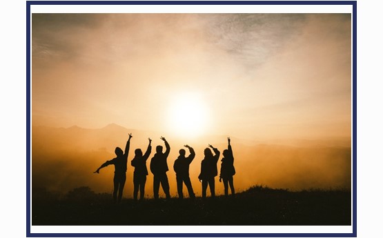 a group of people silhouetted against the sun