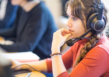 Student translating text wearing headphones