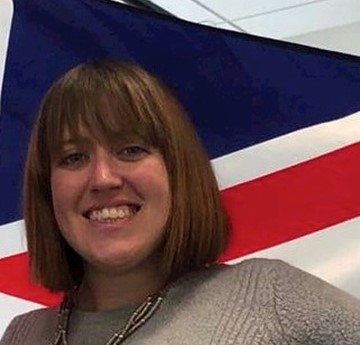 Caroline Stotesbury in front of a red, white, and blue flag