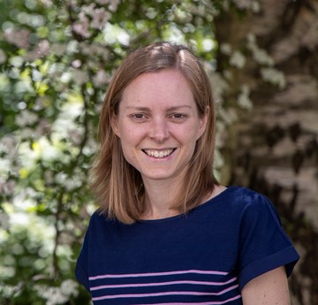 Ceryn Evans in front of a leafy background 