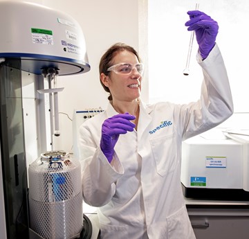 Dr Jenny Baker in a lab holding a test-tube 