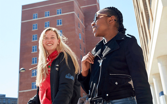 Two students walking through bay Campus