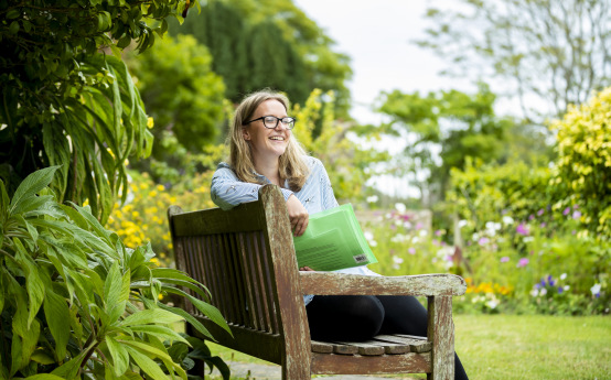 Woman sitting on a bench holding a folder