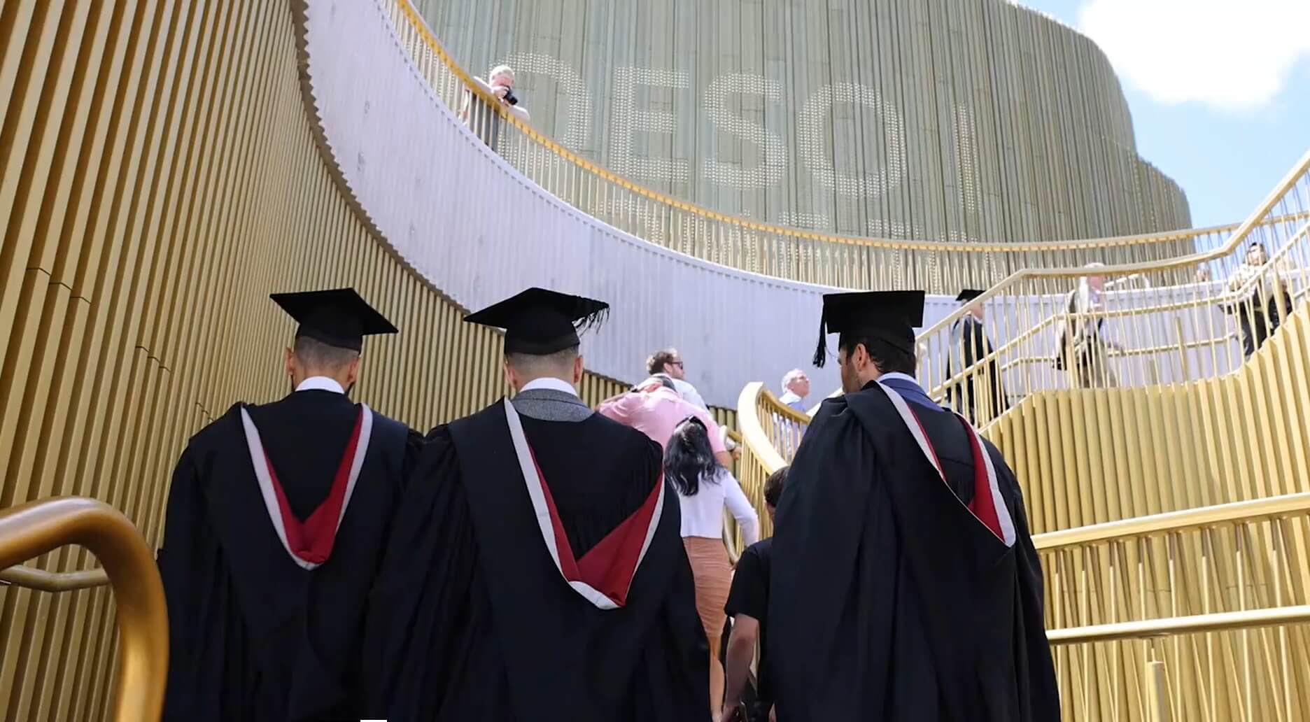 graduates walking to the arena