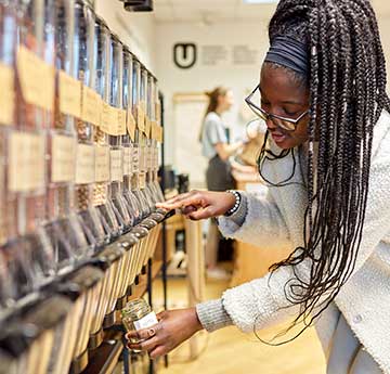 An image of a student shopping in the Root Zero low waste store on Singleton Campus, Swansea University.