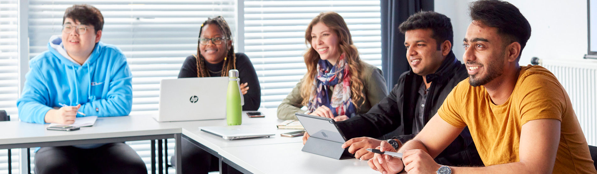 Five students attentively listening in a seminar