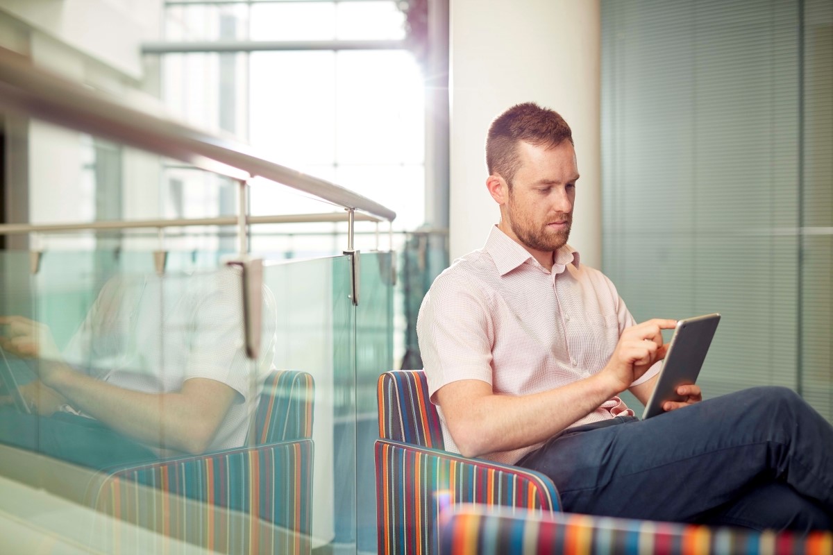 Man seated and using an iPad