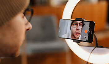 A student filming himself with a smartphone