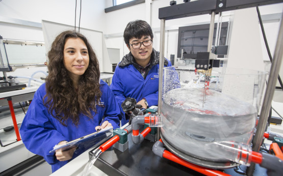 Male and female students in fluids lab