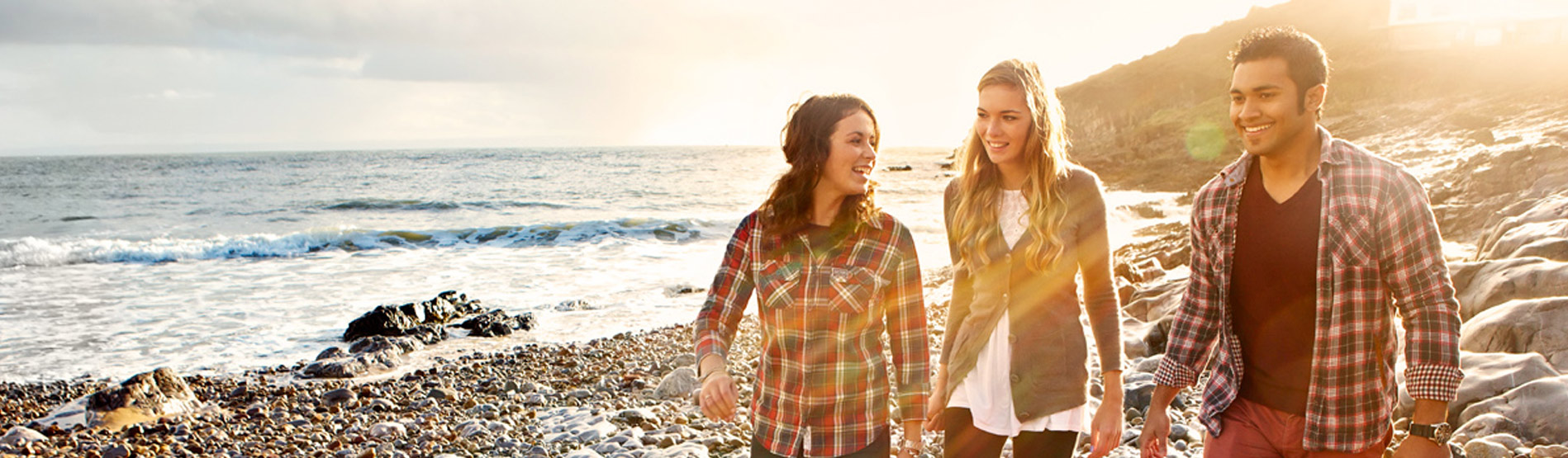 Three students walking across the beach