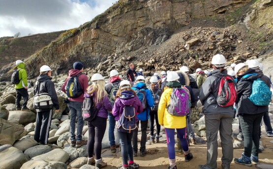 Geography students looking at rocks on a field trip