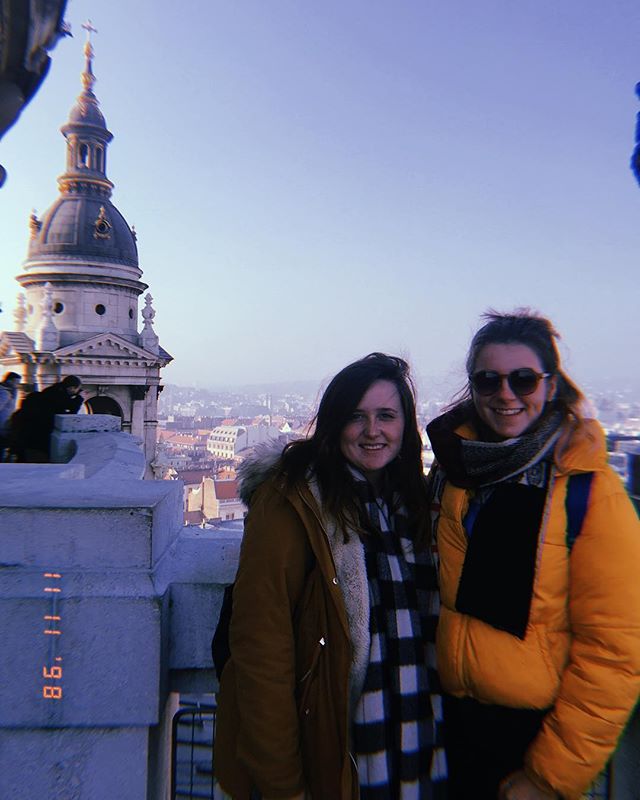 Two female students by building