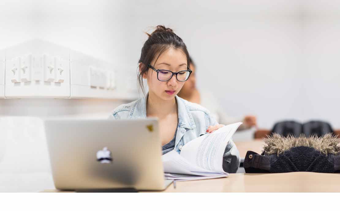 student researching at a laptop