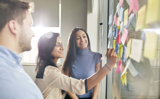 Image of young adults looking happy and project planning 