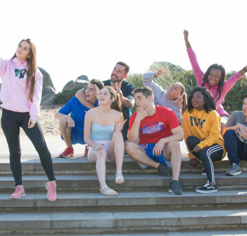 Group of students on steps by beach taking a photo