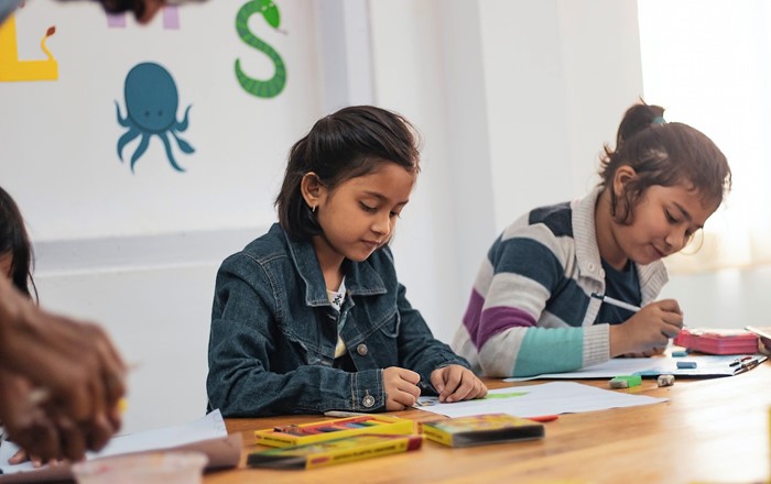 Two girls drawing in school