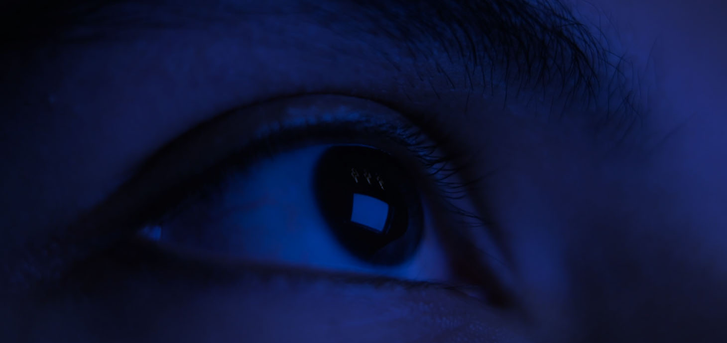 A computer screen reflected on a close-up image of an eye.