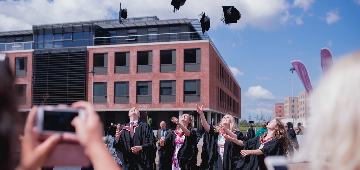 A group of students throwing their graduation caps in the air.