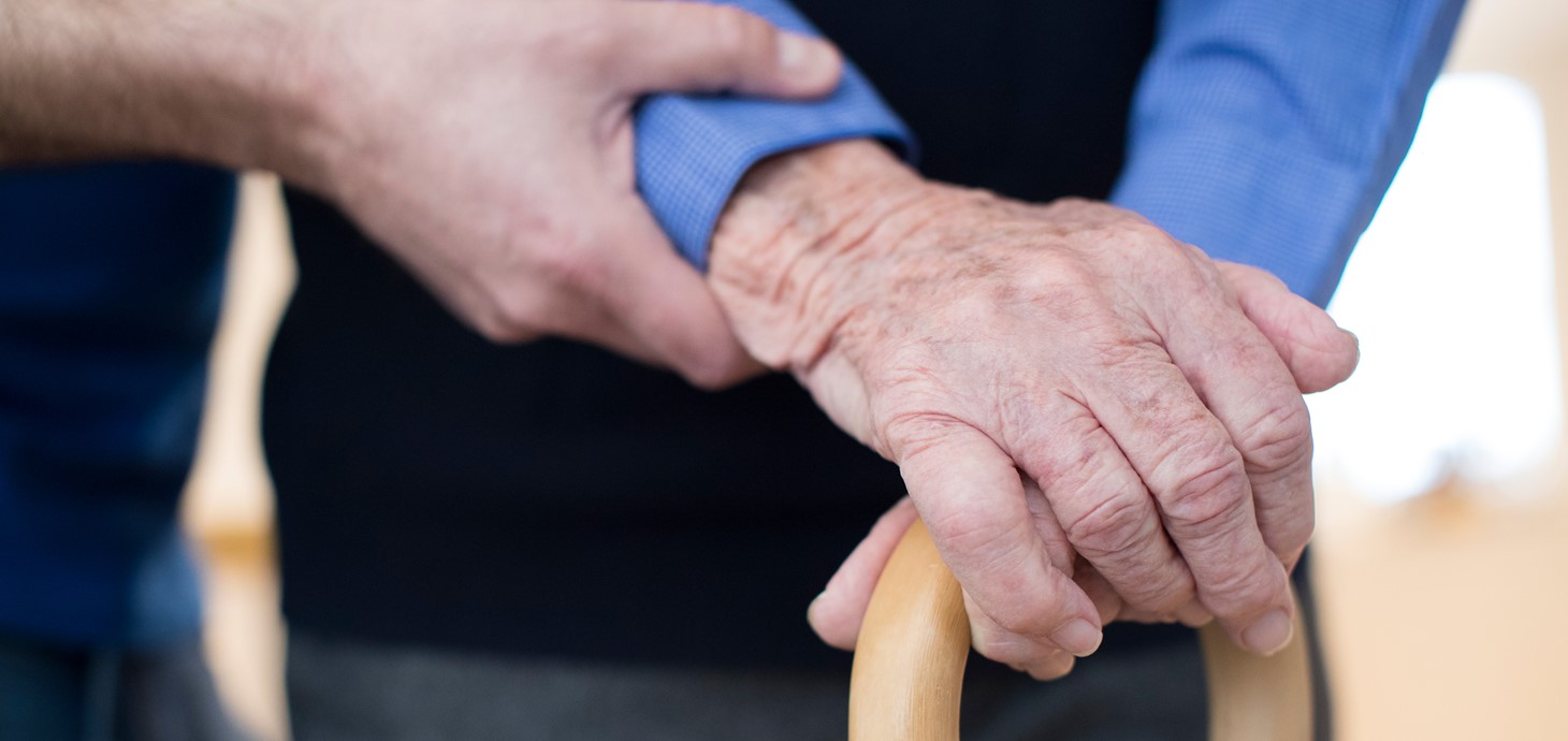 An elderly man's hand on a walking stick 