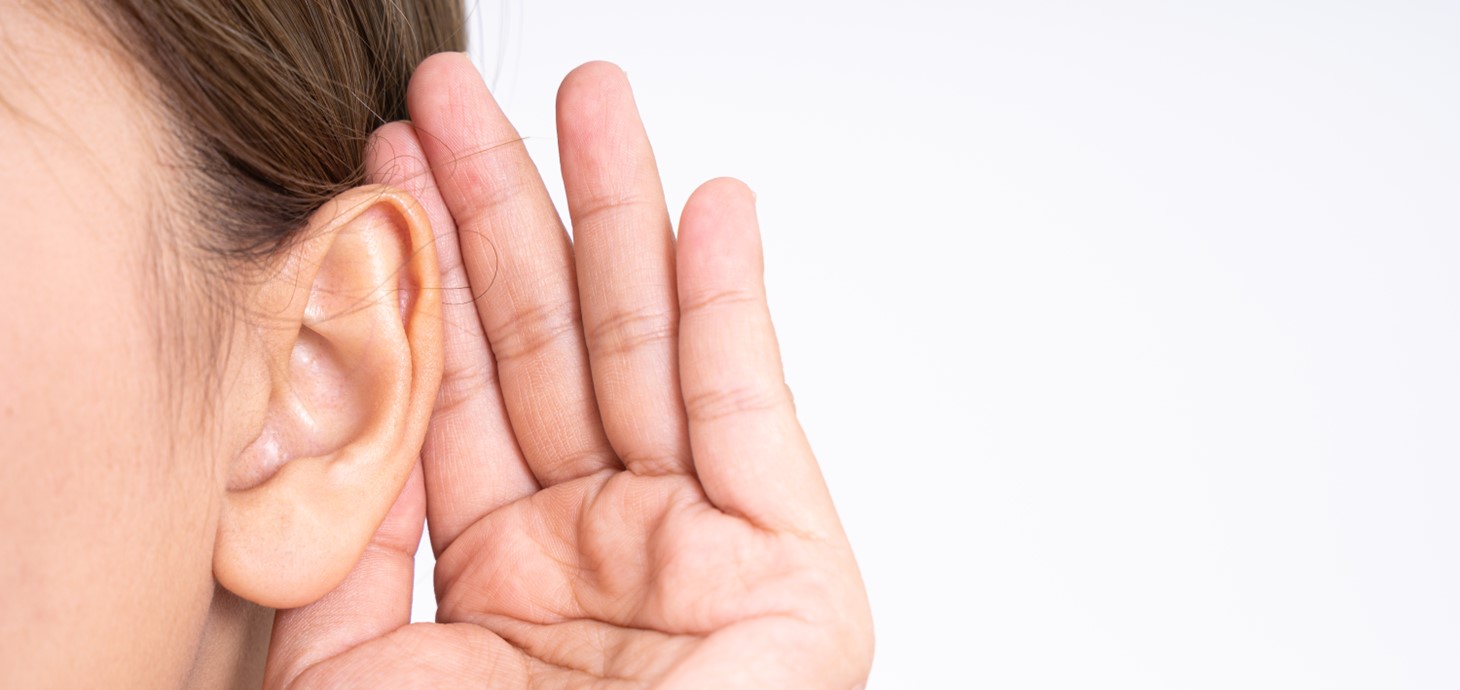 A person cupping their hand behind their ear.