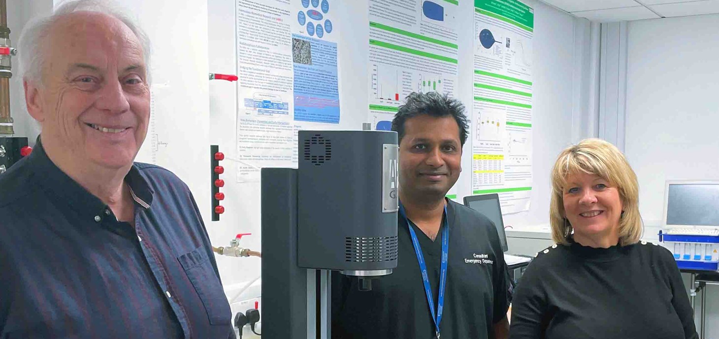 Two men and a woman standing in a medical research laboratory