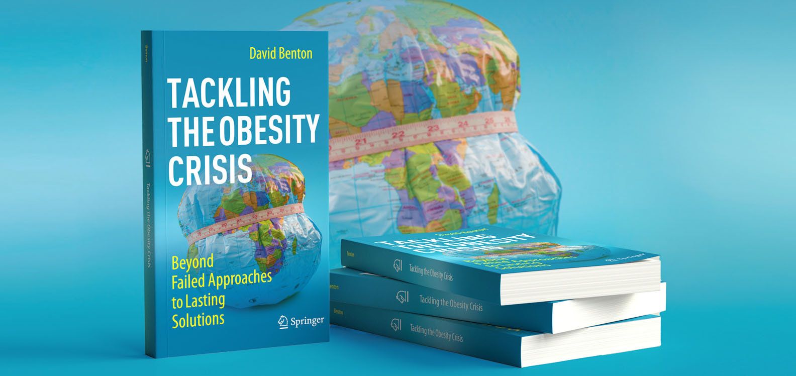Copies of Professor David Benton's new book, Tackling the Obesity Crisis: Beyond Failed Approaches to Lasting Solutions. In the background is a graphic of an inflatable globe with a measuring tape around it.