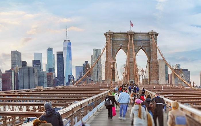 People crossing the Brooklyn Bridge, New York. Corrosion of metal is estimated to cost around $2.2 trillion, more than 3% of global GDP. It can also cost lives. Any product that includes metal - buildings, bridges, cars, aeroplanes – becomes weaker and less safe if corrosion takes hold.