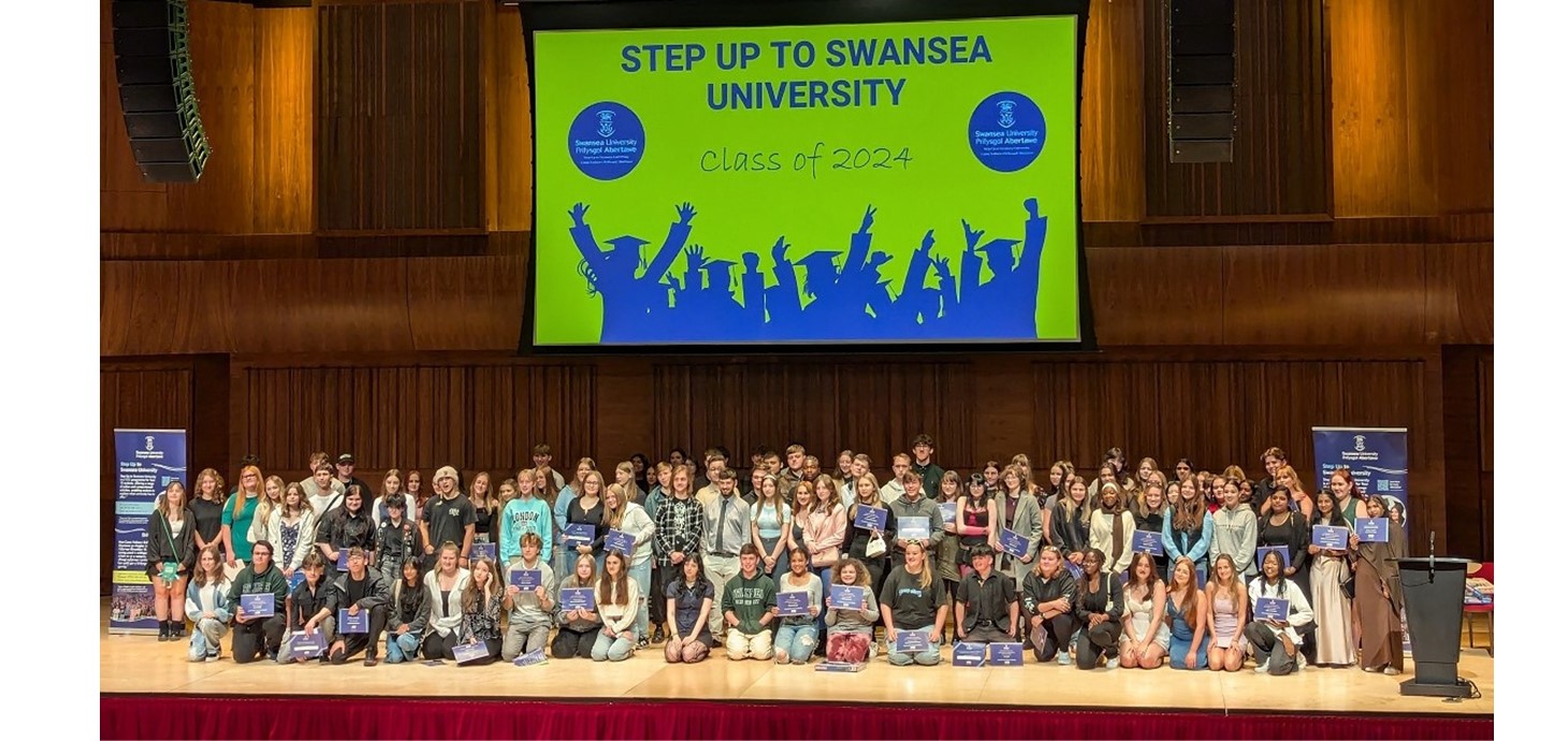 Graduates of the 2024 Step Up Programme on stage at the Great Hall on Swansea University campus. 137 young people from 16 schools and colleges across the region completed the programme and graduated