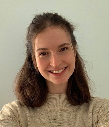 Student taking a selfie by blank wall 