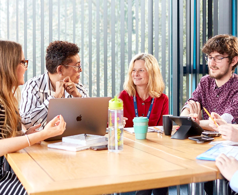 4 adults around a table having a meeting 