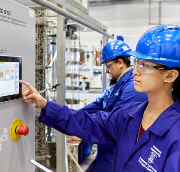 Chemical engineering student in lab looking at equipment