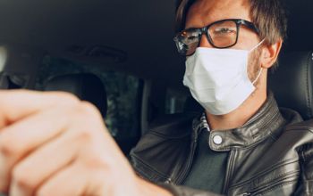 Man driving a car with a face mask on