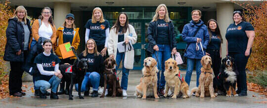 A group of school dogs & their handlers outside an elementary school in Kelowna