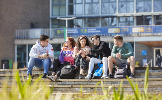 Students sitting on the steps outside Fulton House