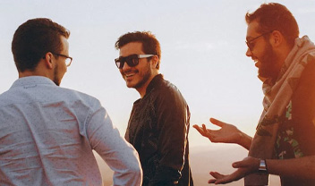 Some men walking and talking on a beach