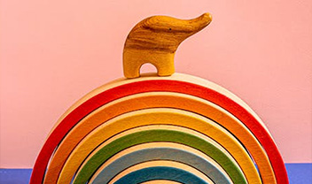 A toy elephant atop a wooden rainbow