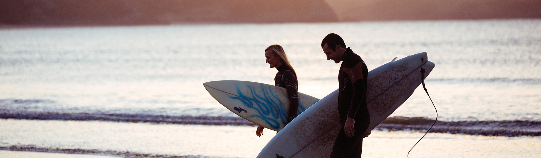 Surfers walking on the beach.