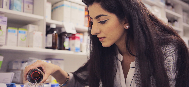 Pharmacist pouring medicine. 