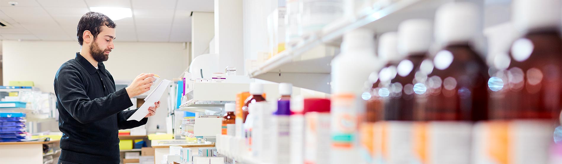 Student looking at Medicine Bottles in a Pharmacy 